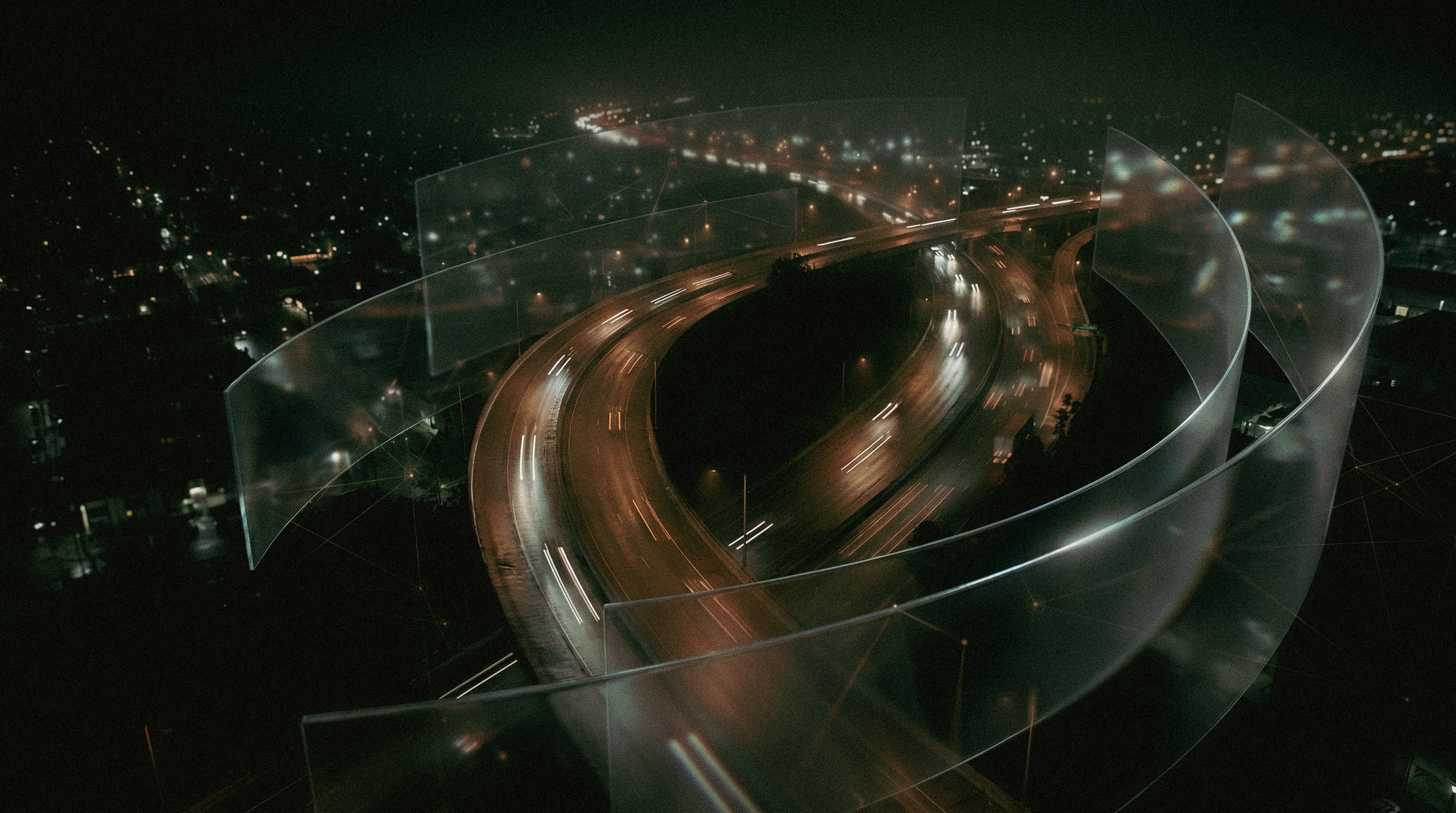 A liquid glass data layer wrapping a nighttime highway interchange