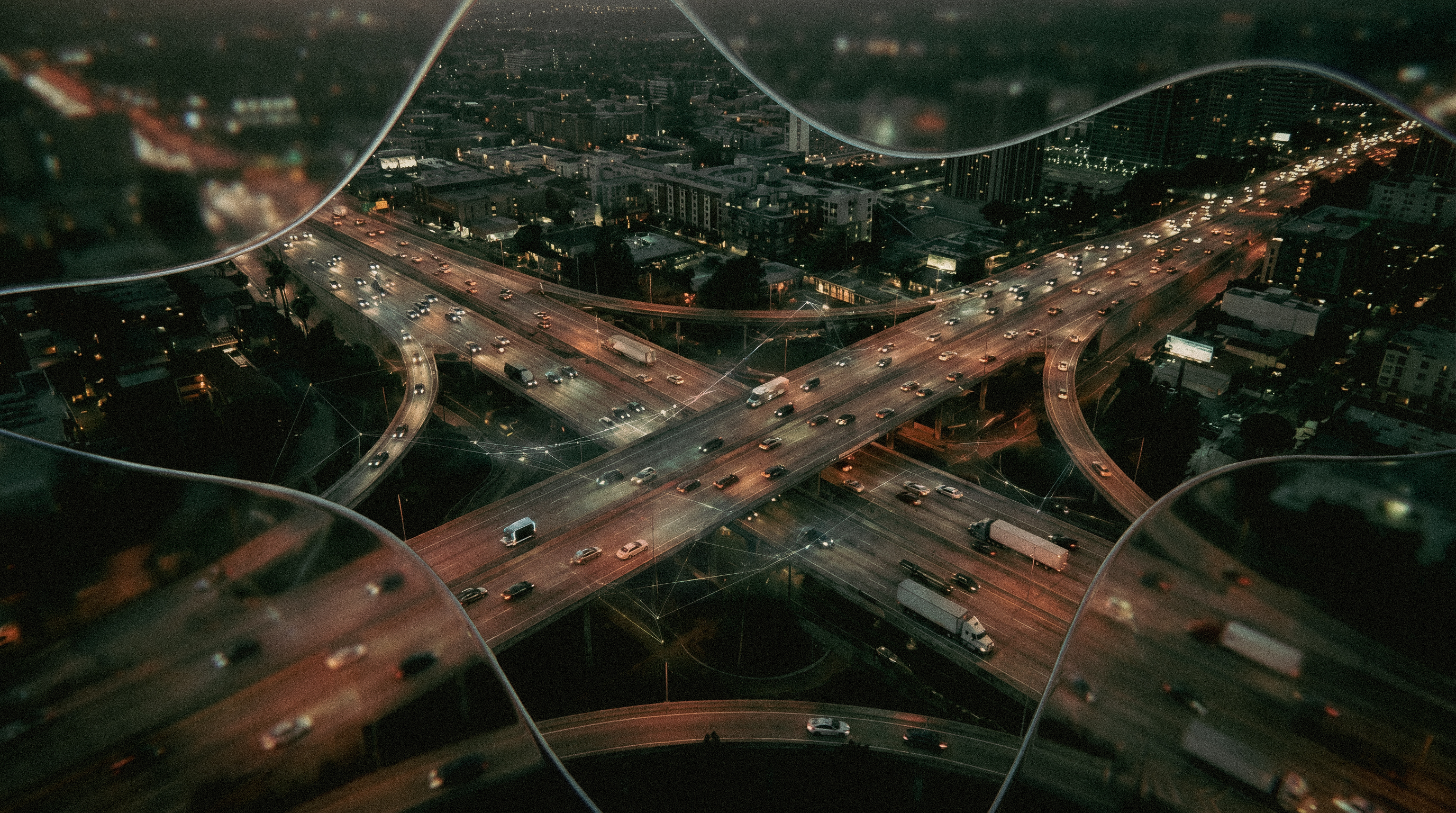 A liquid glass intelligence layer wrapping a nighttime highway interchange